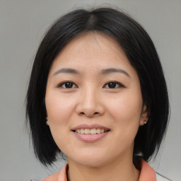 Joyful asian young-adult female with medium  black hair and brown eyes