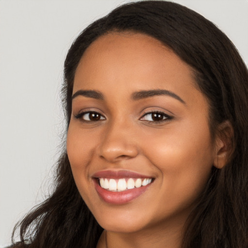 Joyful latino young-adult female with long  brown hair and brown eyes