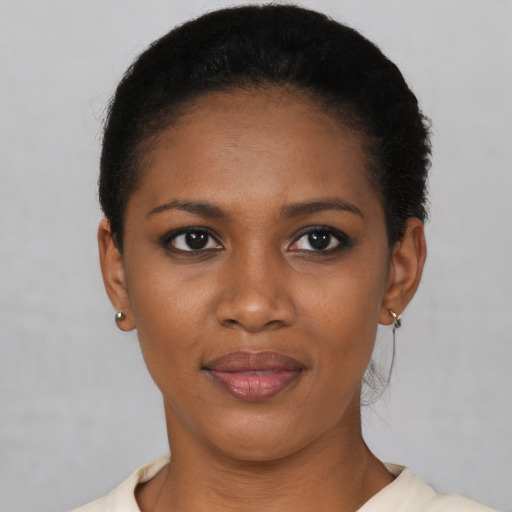 Joyful black young-adult female with short  black hair and brown eyes