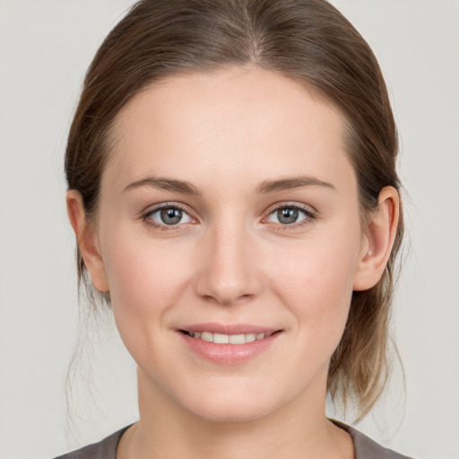 Joyful white young-adult female with medium  brown hair and grey eyes