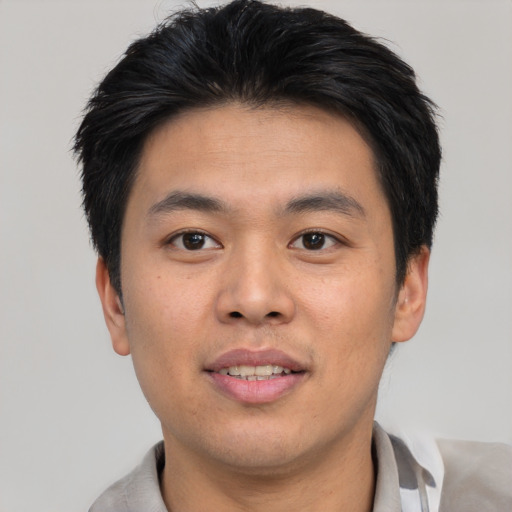 Joyful asian young-adult male with short  brown hair and brown eyes