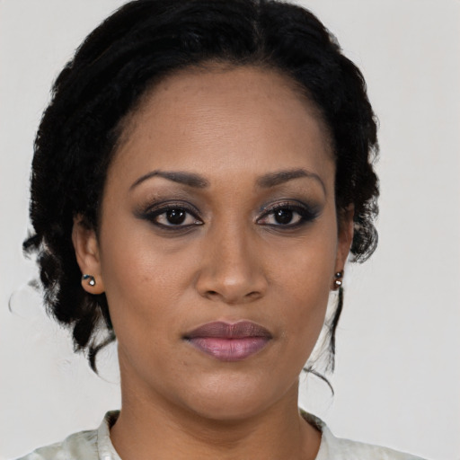 Joyful black young-adult female with medium  black hair and brown eyes