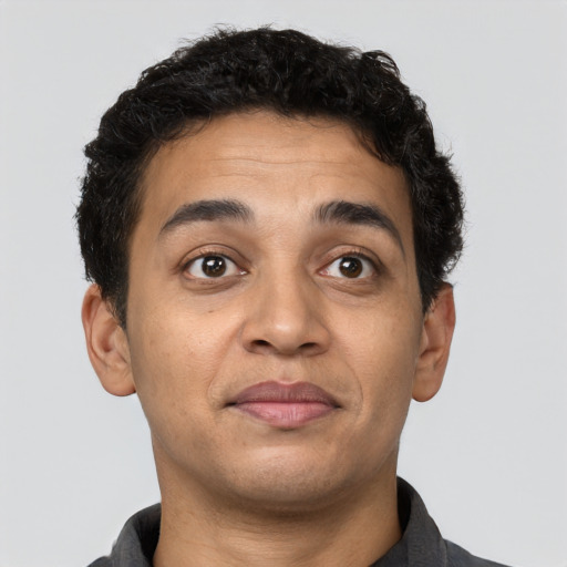 Joyful latino young-adult male with short  brown hair and brown eyes