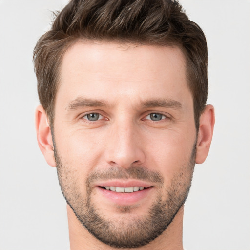 Joyful white young-adult male with short  brown hair and grey eyes