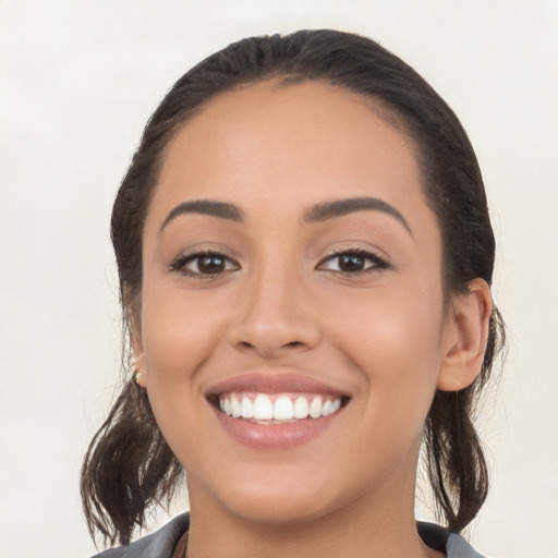 Joyful white young-adult female with long  brown hair and brown eyes