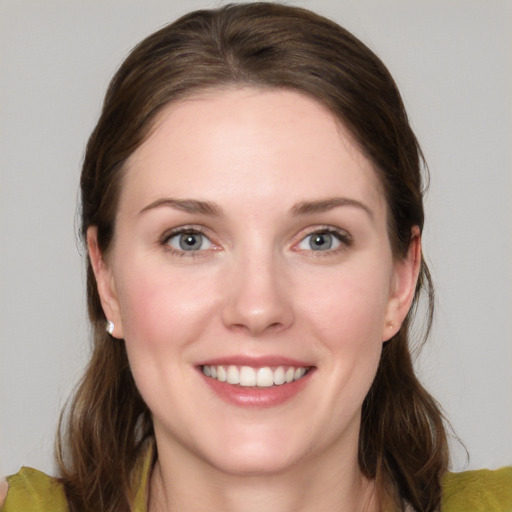 Joyful white young-adult female with medium  brown hair and grey eyes