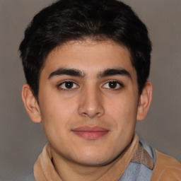 Joyful latino young-adult male with short  brown hair and brown eyes