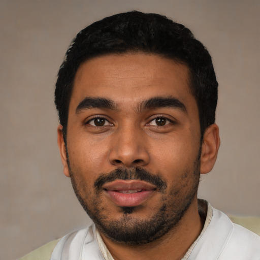 Joyful latino young-adult male with short  black hair and brown eyes