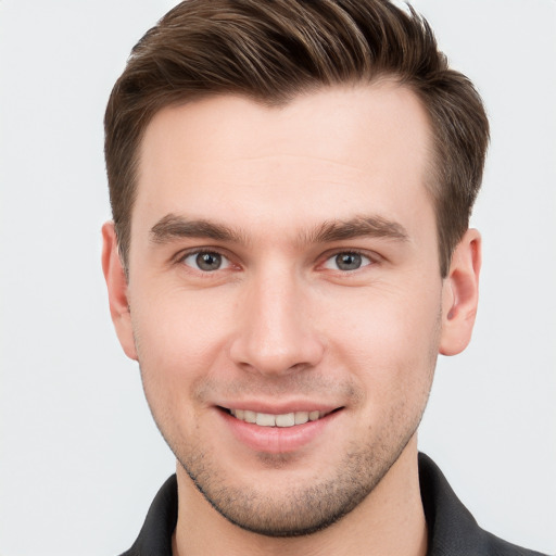 Joyful white young-adult male with short  brown hair and grey eyes