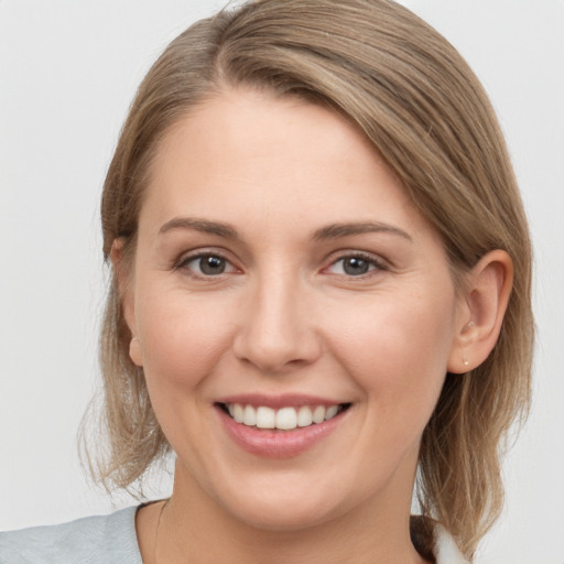 Joyful white young-adult female with medium  brown hair and grey eyes