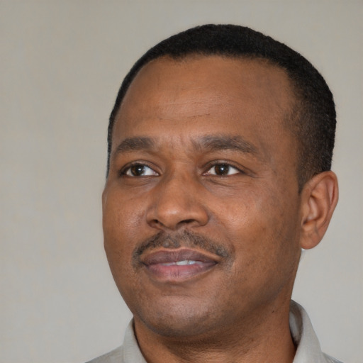 Joyful black adult male with short  brown hair and brown eyes