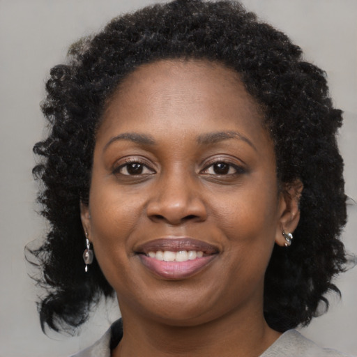 Joyful black young-adult female with medium  brown hair and brown eyes