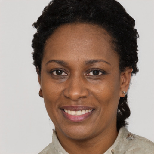 Joyful black adult female with short  black hair and brown eyes