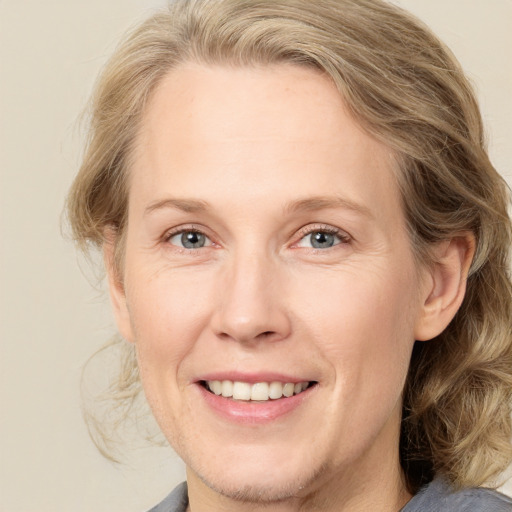 Joyful white adult female with medium  brown hair and blue eyes