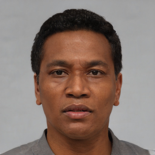 Neutral latino adult male with short  black hair and brown eyes