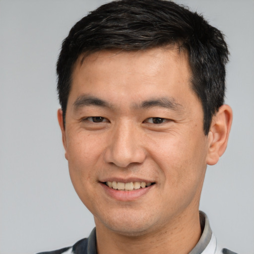 Joyful white adult male with short  black hair and brown eyes