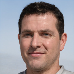 Joyful white adult male with short  brown hair and brown eyes