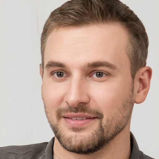 Joyful white young-adult male with short  brown hair and grey eyes