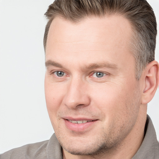 Joyful white adult male with short  brown hair and brown eyes