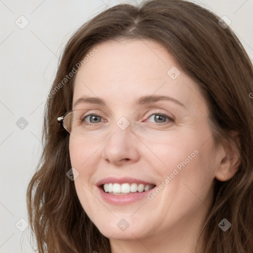 Joyful white young-adult female with long  brown hair and blue eyes