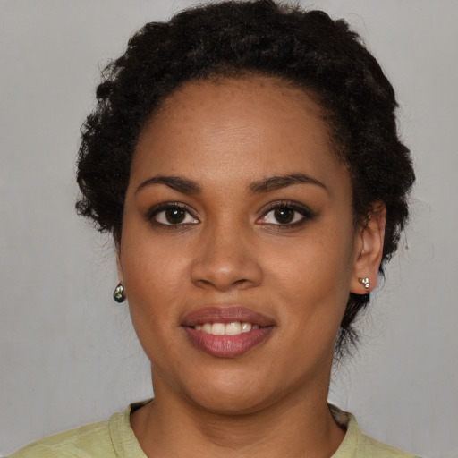 Joyful black young-adult female with short  black hair and brown eyes