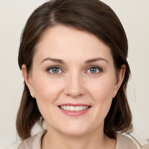 Joyful white young-adult female with medium  brown hair and grey eyes