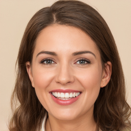 Joyful white young-adult female with long  brown hair and brown eyes