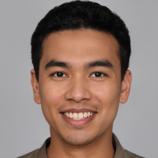 Joyful latino young-adult male with short  black hair and brown eyes