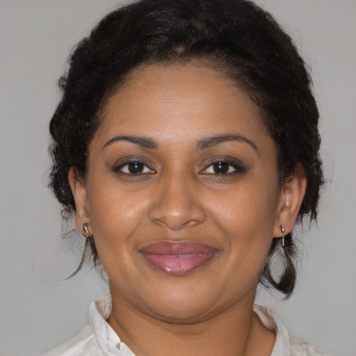 Joyful black adult female with medium  brown hair and brown eyes