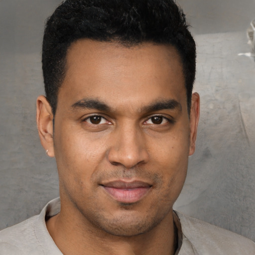 Joyful latino young-adult male with short  brown hair and brown eyes