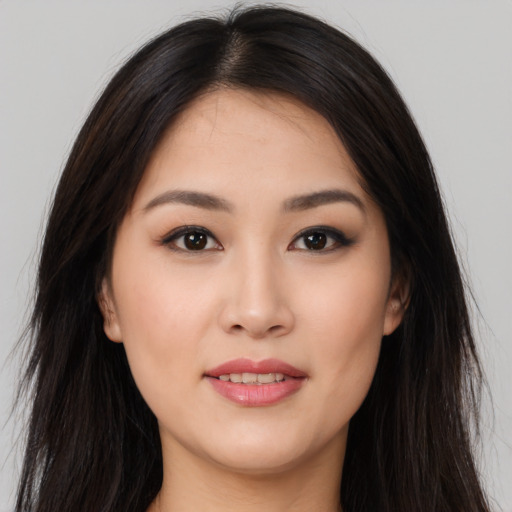 Joyful asian young-adult female with long  brown hair and brown eyes