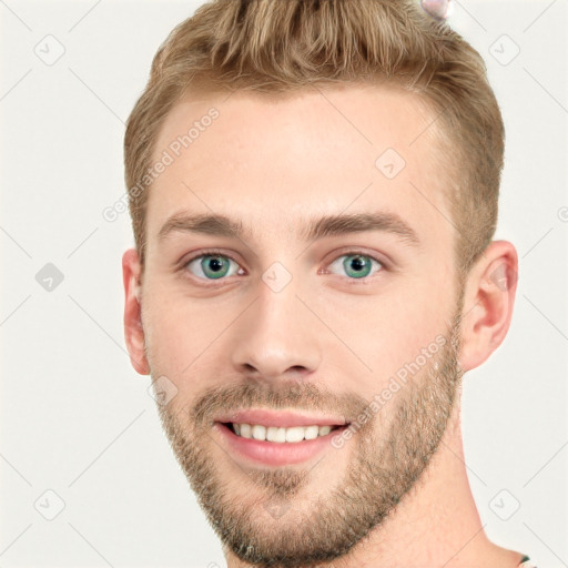 Joyful white young-adult male with short  brown hair and blue eyes