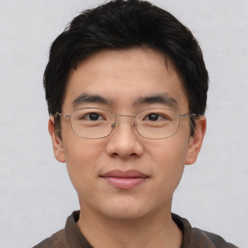 Joyful asian adult male with short  black hair and brown eyes