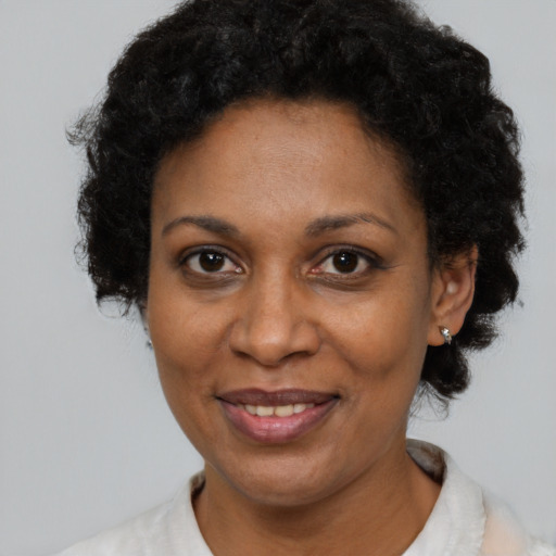 Joyful black adult female with short  brown hair and brown eyes