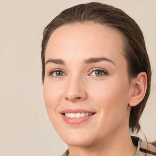 Joyful white young-adult female with medium  brown hair and grey eyes