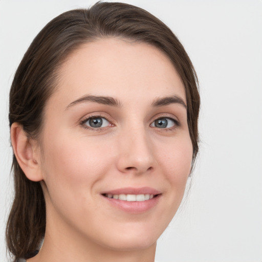 Joyful white young-adult female with medium  brown hair and grey eyes