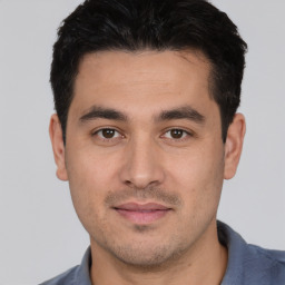 Joyful white young-adult male with short  black hair and brown eyes