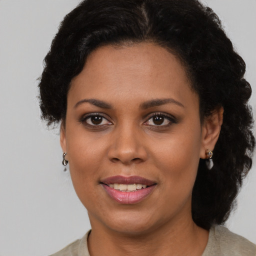 Joyful black adult female with short  brown hair and brown eyes
