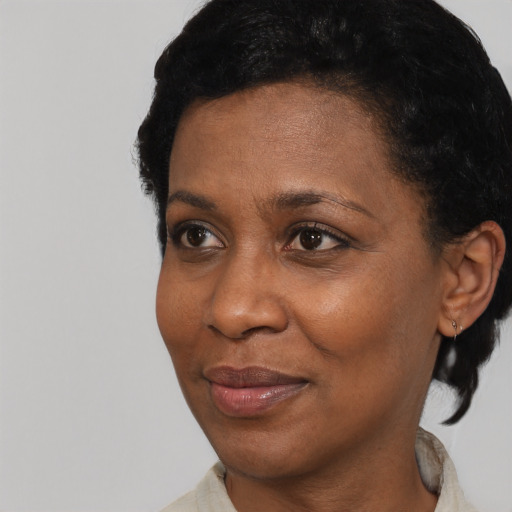 Joyful black adult female with short  black hair and brown eyes