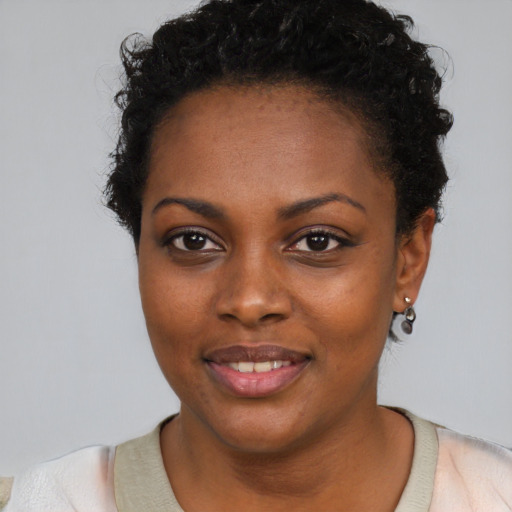 Joyful black young-adult female with short  brown hair and brown eyes