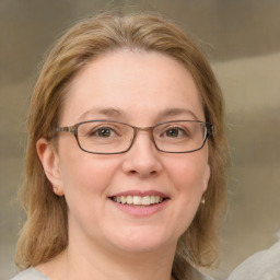 Joyful white adult female with medium  brown hair and green eyes