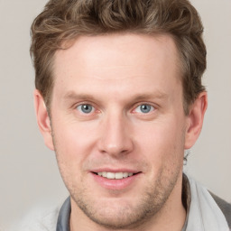 Joyful white young-adult male with short  brown hair and grey eyes