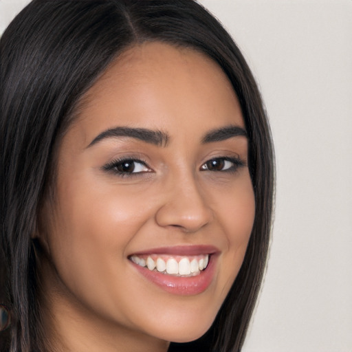 Joyful latino young-adult female with long  brown hair and brown eyes