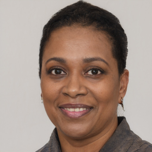 Joyful black adult female with short  black hair and brown eyes
