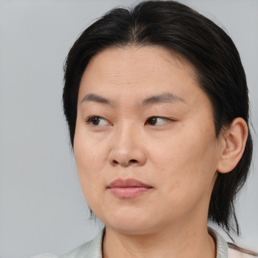 Joyful asian adult female with medium  brown hair and brown eyes