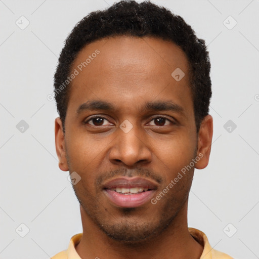 Joyful black young-adult male with short  brown hair and brown eyes