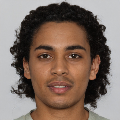 Joyful black young-adult male with short  black hair and brown eyes