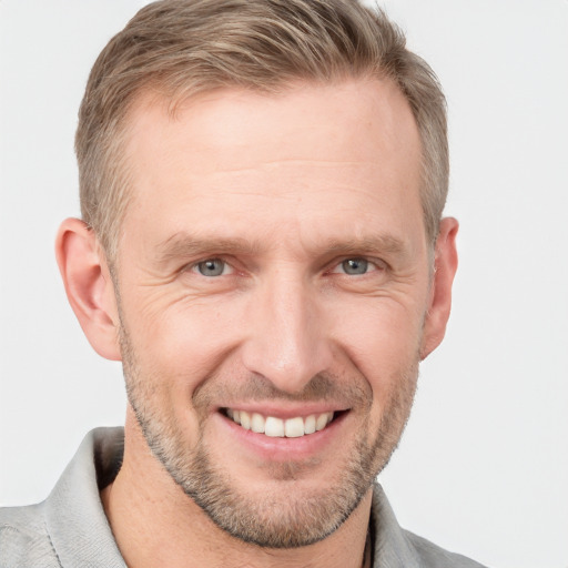 Joyful white adult male with short  brown hair and blue eyes