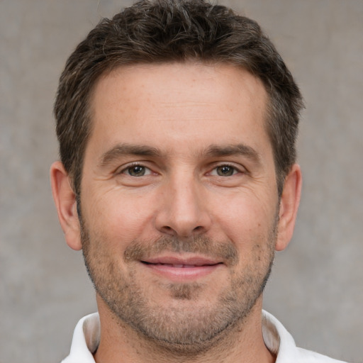 Joyful white adult male with short  brown hair and brown eyes