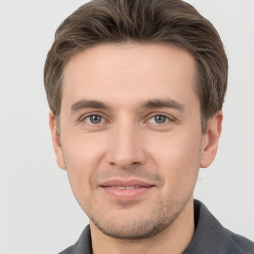 Joyful white young-adult male with short  brown hair and grey eyes